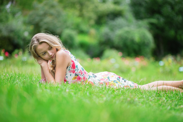 Chica joven acostada en la hierba en un día de verano
 - Foto, Imagen
