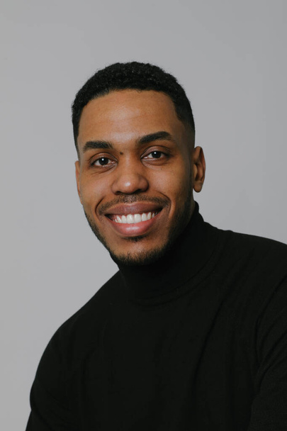 Portrait of millennial African American man posing over white wall. Vertical. - Φωτογραφία, εικόνα