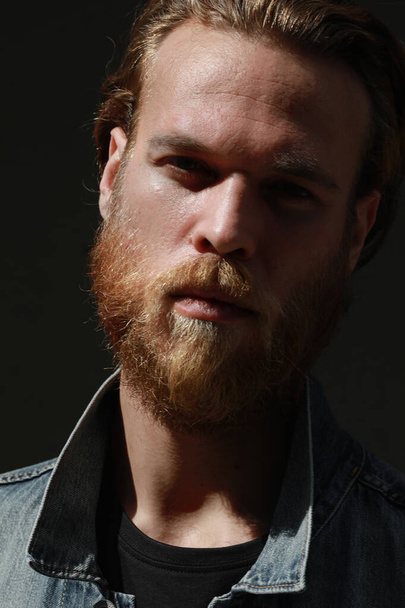 Close-up of bearded hipster man posing outdoor wears denim jacket. Vertical. - Photo, Image