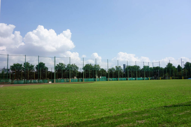 Летнее голубое небо, ухоженная тишина под палящим солнцем, тихий бейсбольный забор - Фото, изображение
