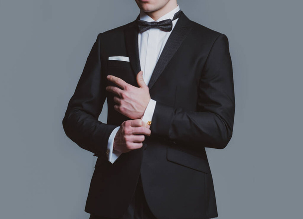 Business fashion look. Man fixing cufflinks. Gentleman in black suit. Elegant and stylish clothes. - Fotó, kép