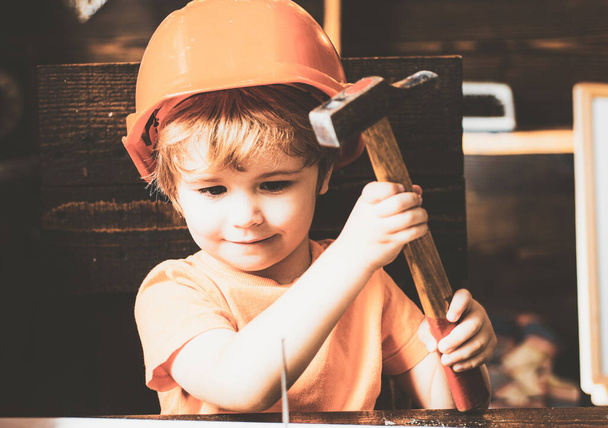 Il bambino con un martello fa le riparazioni. Il bambino partecipa attivamente al processo fatto a mano. - Foto, immagini
