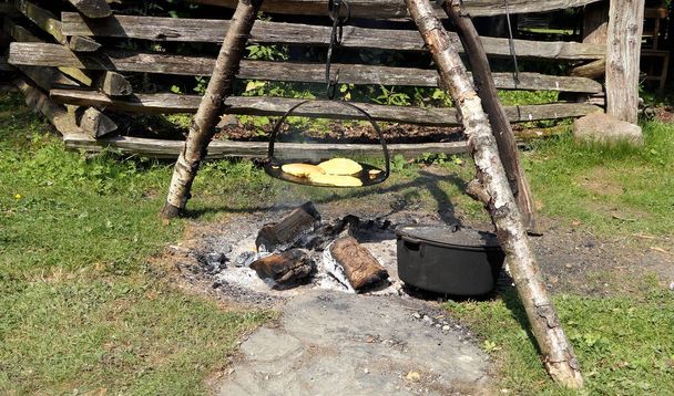 Hornear pan en una plancha sobre un fuego al aire libre en América de 1800  - Foto, Imagen