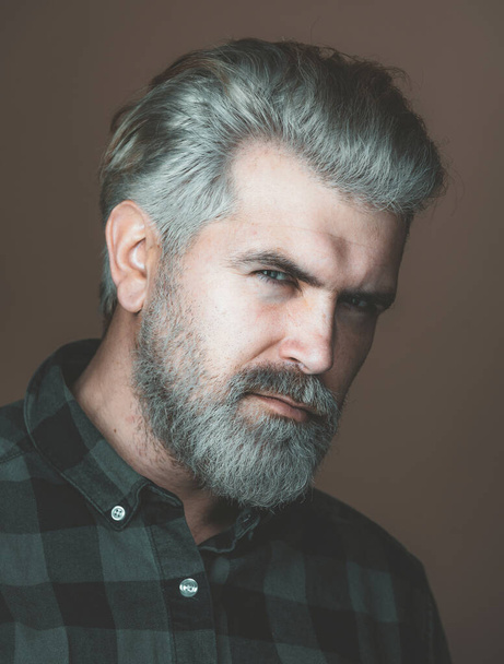 Mature blonde bearded guy with trendy hairdo in casual shirt smiling and looking in camera. Close up portrait of a very handsome man. - Фото, зображення
