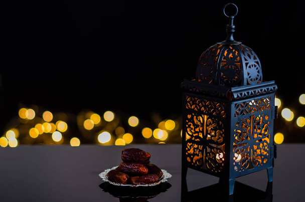 Lanterna e tâmaras fruta no fundo escuro com luz bokeh para a festa muçulmana do mês santo do Ramadã Kareem. - Foto, Imagem