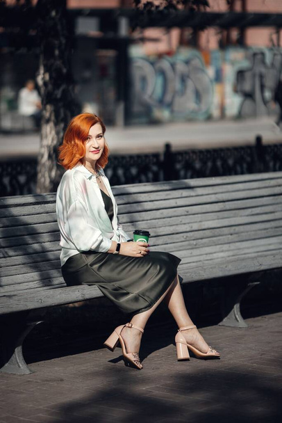 A red-haired woman in the city center, walking down the street. High quality photo - Foto, Bild