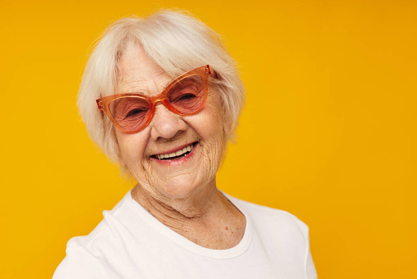 smiling elderly woman vision problems with glasses yellow background - Photo, image