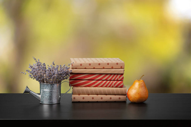 Stack of books on wooden table against blurred background - Foto, afbeelding