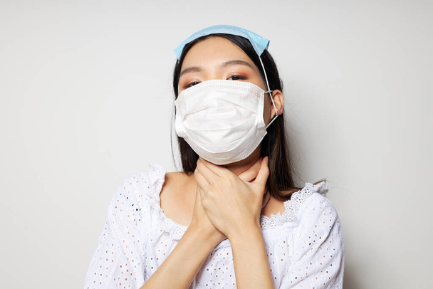 Charming young Asian woman two medical masks on the head protection isolated background unaltered - 写真・画像