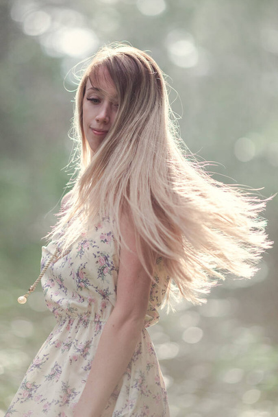 Blondes Mädchen in einem leichten luftigen Kleid, barfuß im Morgengrauen in einem Sommerwald. Hochwertiges Foto - Foto, Bild