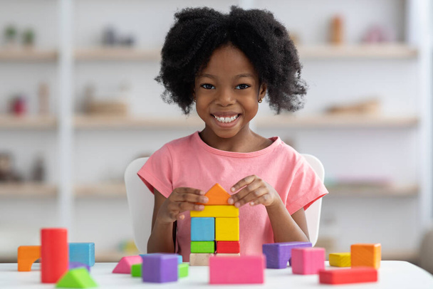 Heureuse petite fille noire jouant avec des blocs de bois colorés - Photo, image