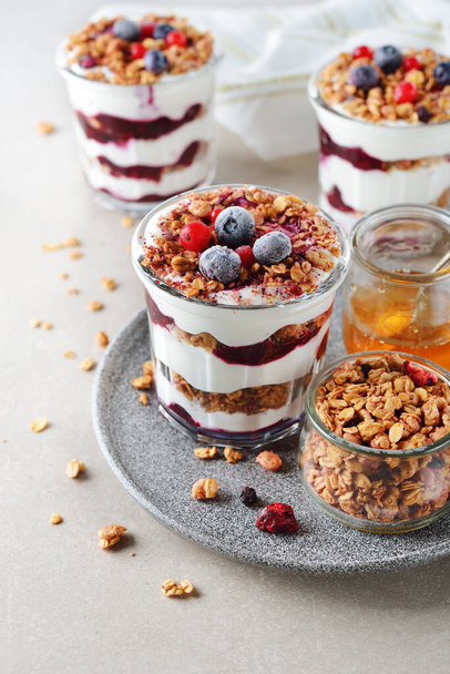 Healthy parfait with muesli berry sauce on a gray background - Foto, Imagen