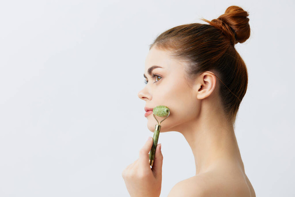 rodillo de masaje de mujer joven tratamiento facial antienvejecimiento primer plano Lifestyle - Foto, Imagen