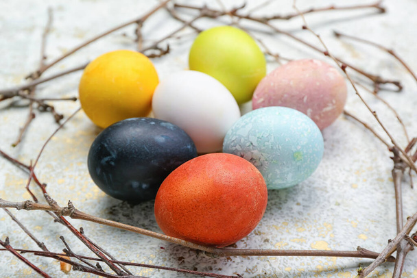 Composition avec de beaux œufs de Pâques et des branches d'arbre sur fond clair, gros plan - Photo, image