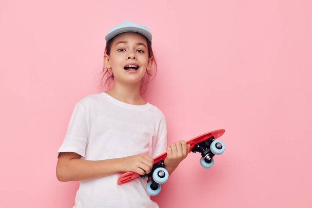 cute girl with a skateboard in hand childhood unaltered - Foto, imagen