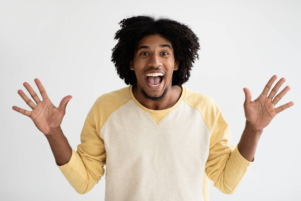 Portrait Of Overjoyed Young African American Guy Raising Hands With Excitement - Foto, afbeelding