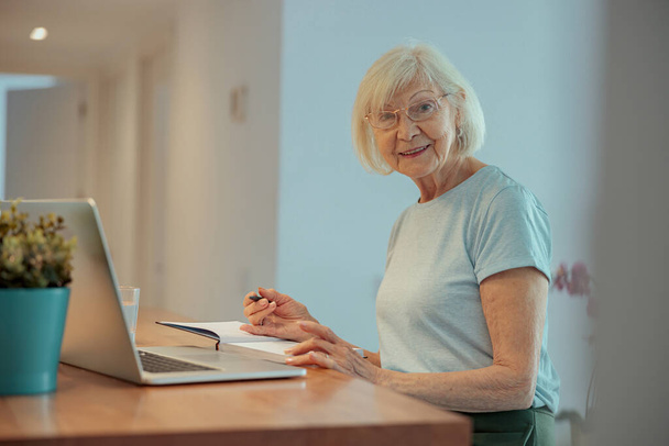 Portret radosnej starszej kobiety z laptopem w pomieszczeniu - Zdjęcie, obraz