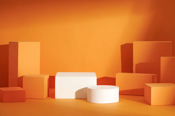 Widok z przodu biały i pomarańczowy podium w pomarańczowym tle do reklamy, abstrakcyjna zawartość - Zdjęcie, obraz