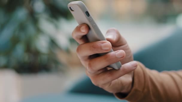 Κοντινό πλάνο αρσενικό χέρι αγνώριστο άνθρωπος κρατώντας τηλέφωνο νεαρός άνδρας ανάγνωση ειδήσεων ψάχνει πληροφορίες χρησιμοποιώντας δωρεάν κινητό μήνυμα δακτυλογράφησης εφαρμογή στο κοινωνικό δίκτυο αγορά online στο smartphone web surfing - Πλάνα, βίντεο