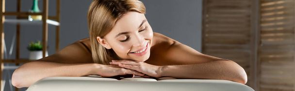 alegre joven mujer acostada en la mesa de masaje, pancarta - Foto, imagen