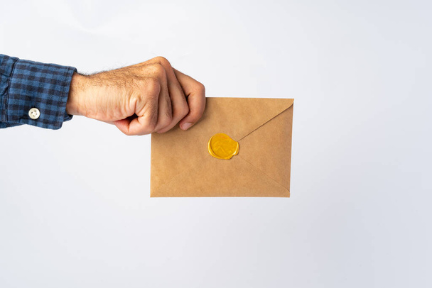 Male hands holding an envelope with a wax seal - Фото, зображення