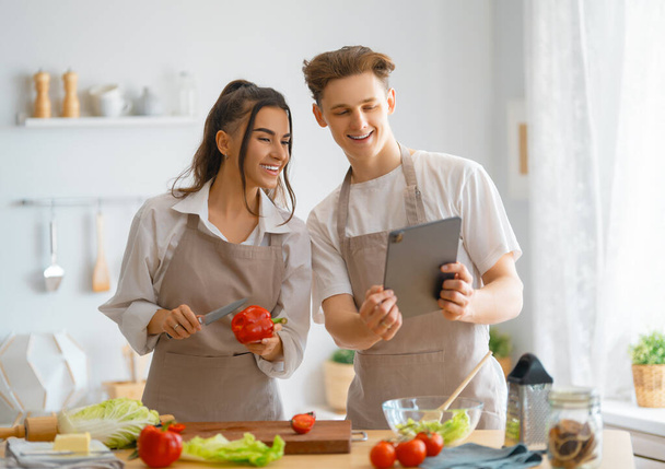 Healthy food at home. Happy loving couple is preparing the proper meal in the kitchen. - Photo, Image