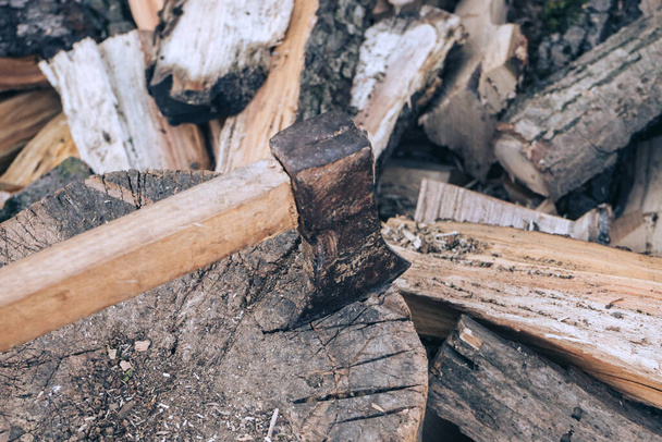 Piękne Stara siekiera z drewnianą rączką leży na stosie drewna opałowego, widok z góry zbliżenie - Zdjęcie, obraz