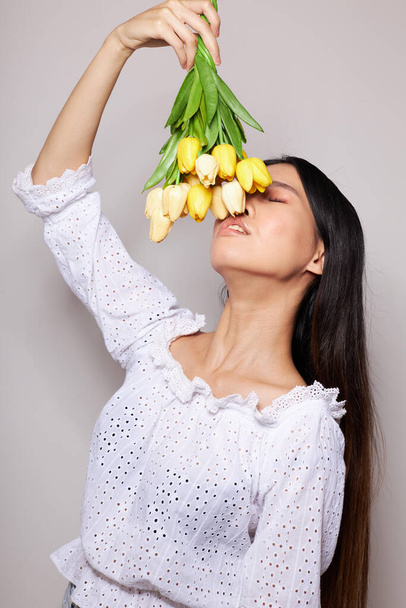 mulher com aparência asiática com um buquê de flores sorriso close-up estúdio modelo inalterado - Foto, Imagem