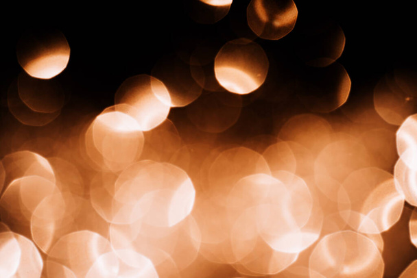 Bright lights of golden color against black background - Foto, Imagen