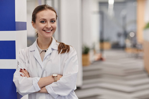 Gelukkig jong vrouwelijk medisch officier dragen lab jas - Foto, afbeelding