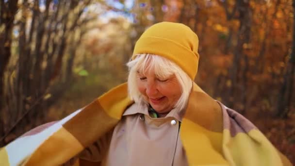 Fröhliche Frau mittleren Alters genießt den Herbst draußen im herbstlichen Stadtpark oder Waldhintergrund. - Filmmaterial, Video