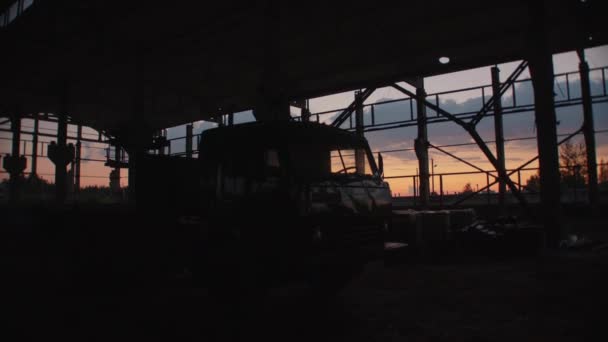 Náklaďák v otevřené skladové budově nebo továrně s kovovými konstrukcemi při západu slunce - Záběry, video