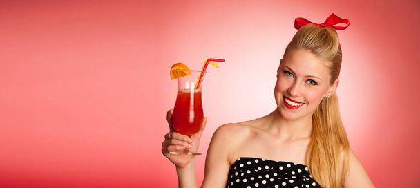beautiful young blond caucasian  pinup woman with a glass of cocktail - Photo, image
