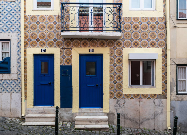 Lisbon, Portugal - 12 28 2018: Typical Portuguese facade with tiles and two small blue doors - Fotó, kép