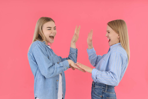 Дві молоді привабливі подружки на рожевому фоні
 - Фото, зображення