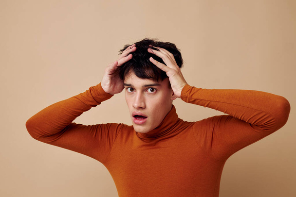 portrait of a young man posing in brown sweater self confidence fashion light background unaltered - Photo, image