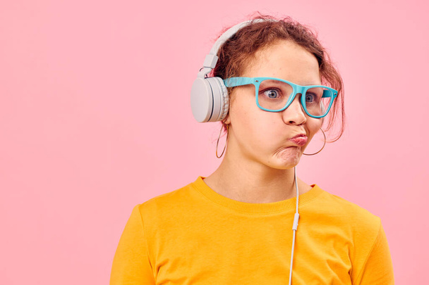 portrait of a young woman yellow t-shirt headphones entertainment music fun isolated backgrounds unaltered - Photo, image
