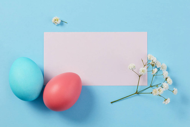 Červená a modrá velikonoční vejce a karta na modrém pozadí - Fotografie, Obrázek