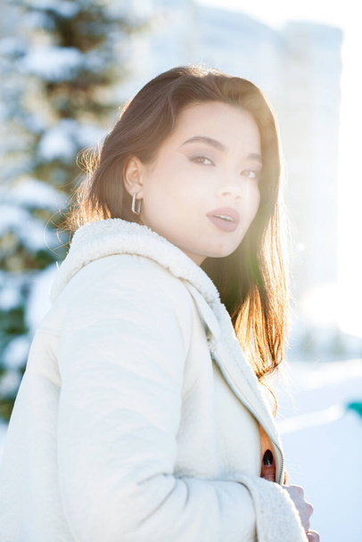 Close up portrait of a young beautiful brunette woman in winter park - Φωτογραφία, εικόνα