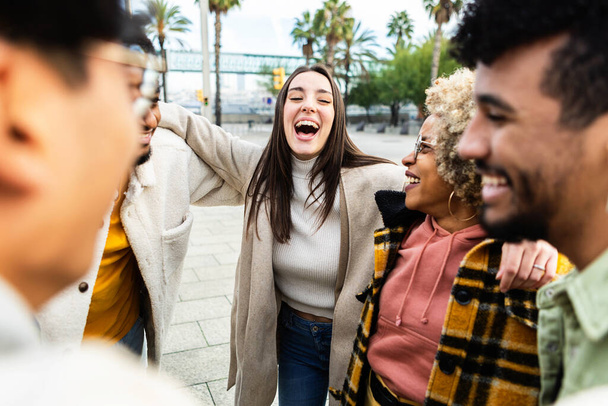 Grupo de amigos multirraciales hablando y riendo en la calle de la ciudad - Foto, imagen