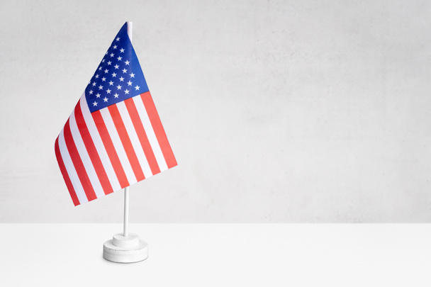 Amerikai asztali zászló szürke texturált falon, másolási hellyel szöveg, tervek vagy rajzok számára - Fotó, kép