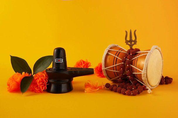 Happy Maha Shivaratri greeting card - Shiva Linga decorated with flowers, trishula, damru and bilva leaves. Hindu festival celebrated of Shiva Lord - 写真・画像