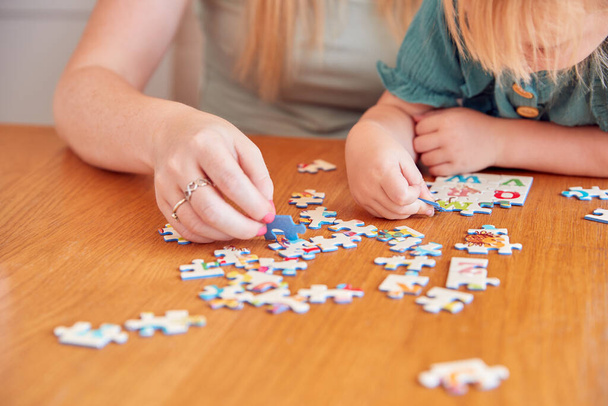 Close Up Of Mother And Daughter Having Fun Sitting At Table At Home Doing Jigsaw Puzzle Together - Fotografie, Obrázek