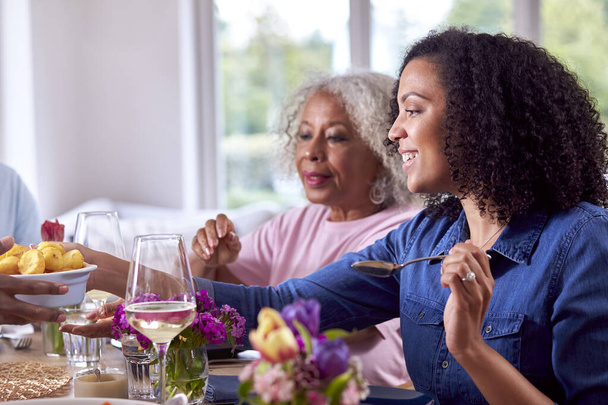 Mother And Adult Daughter Enjoying Multi-Generation Family Meal At Home - Foto, Imagen