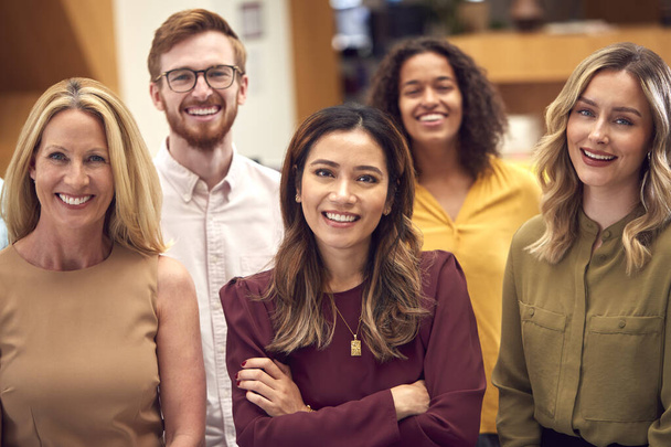 Portrait Of Smiling Multi-Cultural Business Team Standing In Modern Open Plan Office - 写真・画像