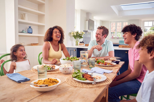 Family Sitting Around Table At Home Eating Meal Together - Photo, Image
