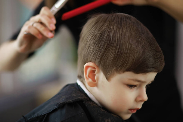 Улыбающийся европейский мальчик в парикмахерской. Готово.. - Фото, изображение