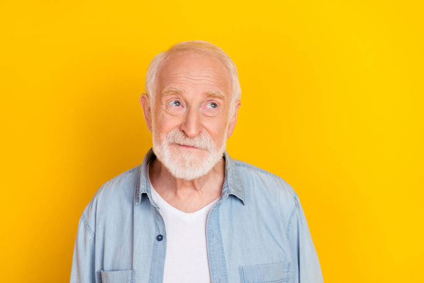 Portrait of attractive bewildered suspicious cheerful grey-haired man deciding isolated over bright yellow color background - Fotoğraf, Görsel