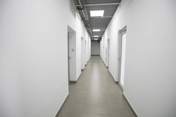 Corredor blanco vacío con puertas cerradas en un edificio de oficinas. - Foto, Imagen