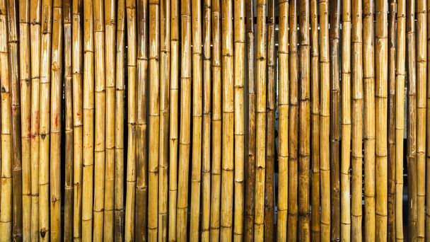 Régi barna árnyalatú bambusz egyszerű fal vagy bambusz kerítés textúra háttér belső vagy külső design vintage hang. Barna bambuszrúd minta háttér. Helyi városi házvédelem a tolvajoktól. - Fotó, kép
